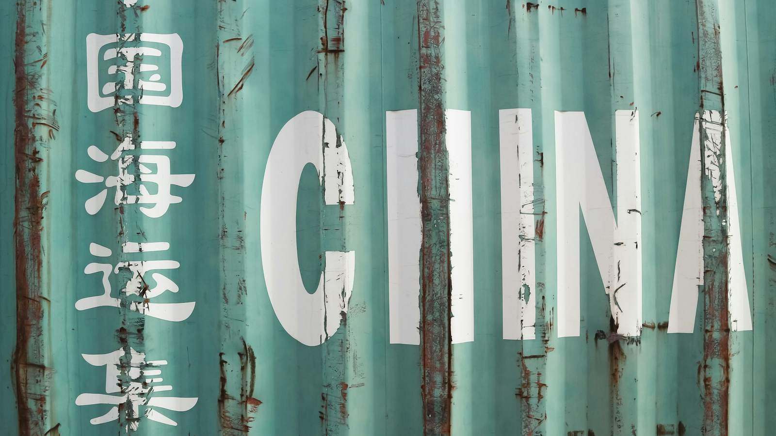 A weathered green shipping container marked CHINA in large white lettering, representing goods originating in China