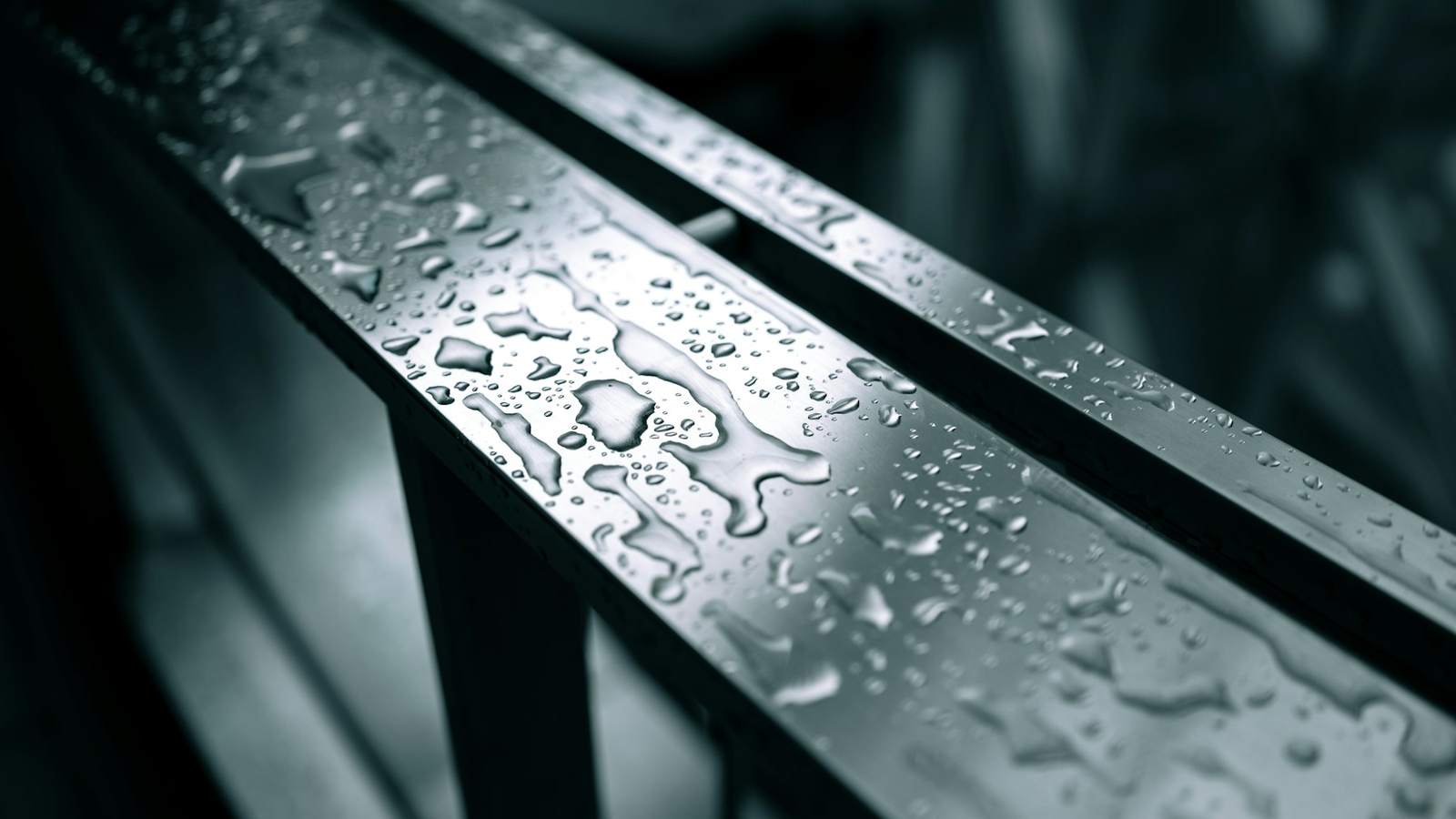 Close-up of water droplets beaded on a grey steel surface, representing the condensation that forms inside a steel shipping container