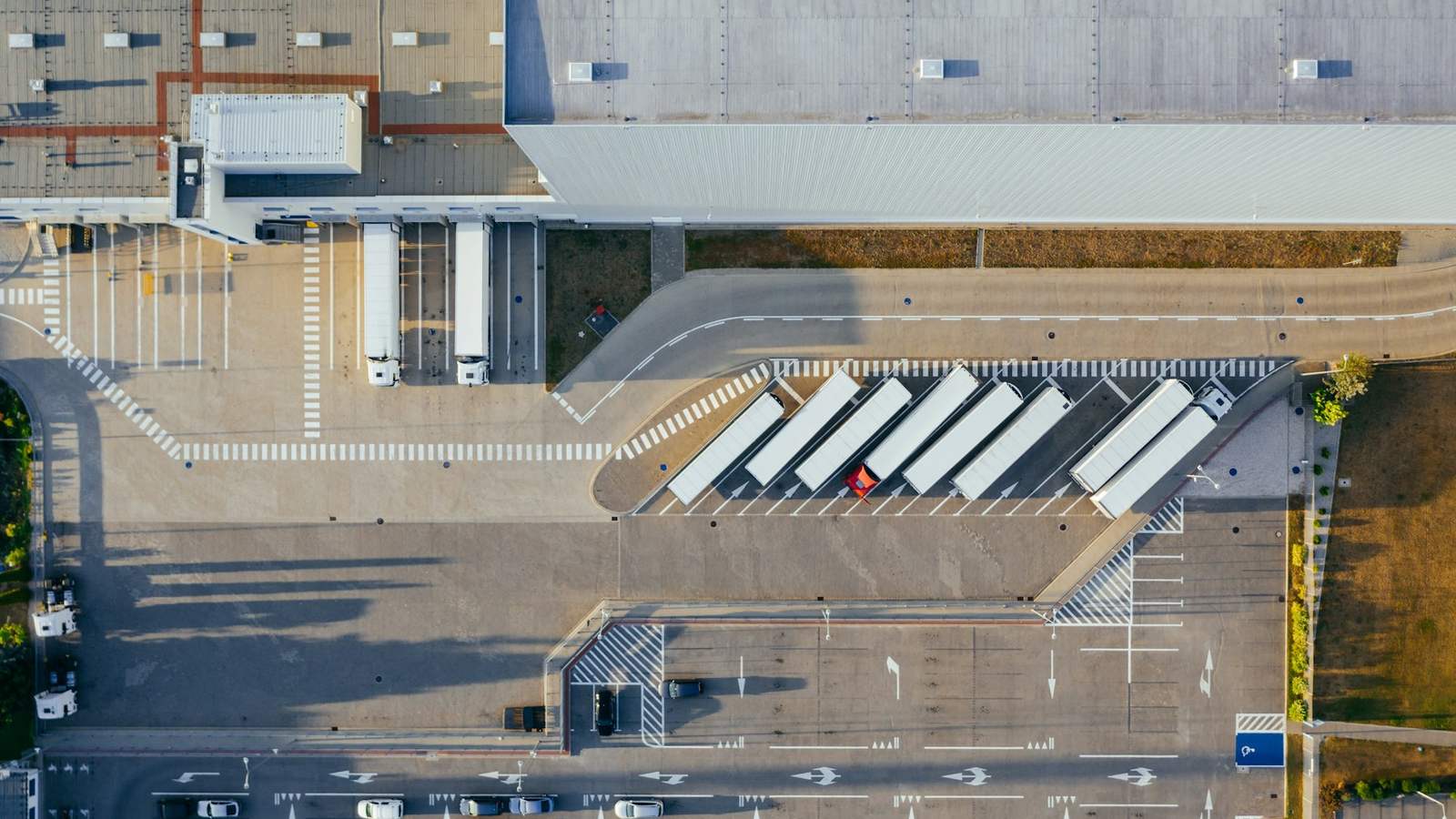 Aerial view of a logistics depot with trailers parked at loading bays, representing the road leg where container weight limits apply