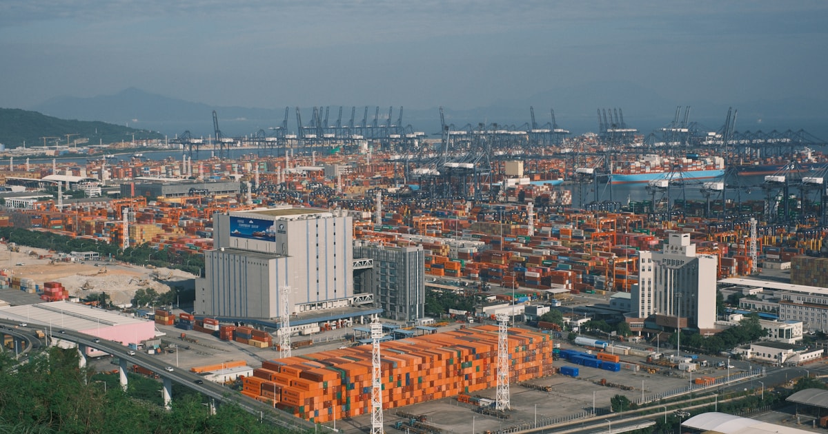 Aerial view of a massive container port packed with stacked cargo containers, representing demurrage and storage charges for cargo sitting at port