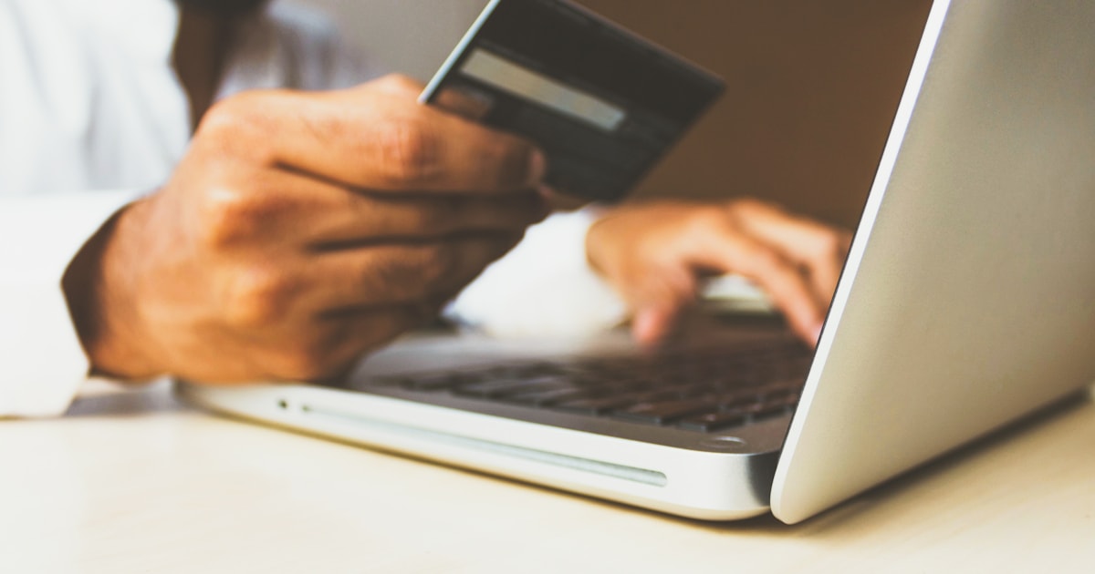 Person making an online payment with a card and laptop, representing how to pay Chinese suppliers safely