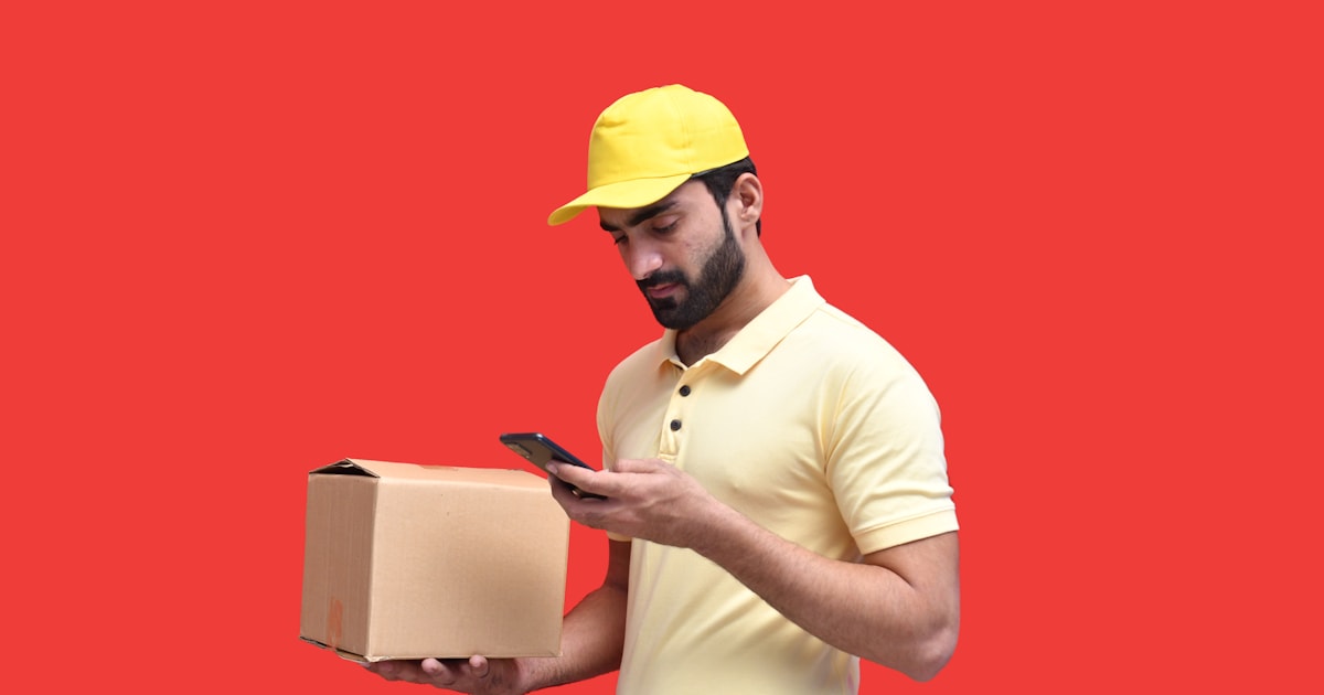 Logistics worker in a hard hat checking a phone, representing how to track your shipment from China