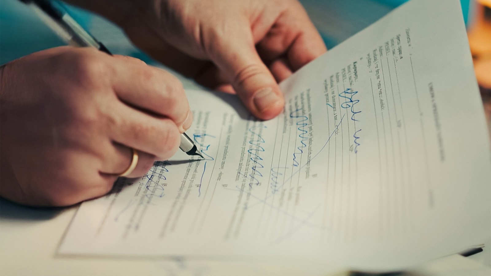 Close-up of hands signing an official application form with a pen, representing the registration paperwork required to become a licensed importer