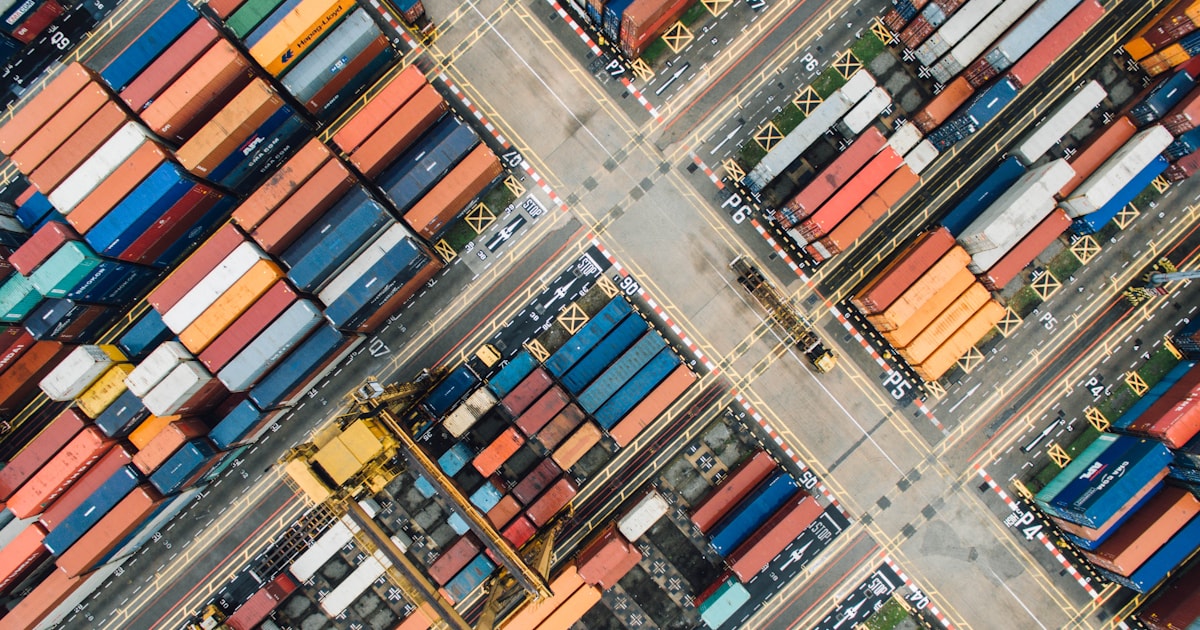 Aerial view of a shipping container yard, illustrating Incoterms FOB, EXW, and CIF