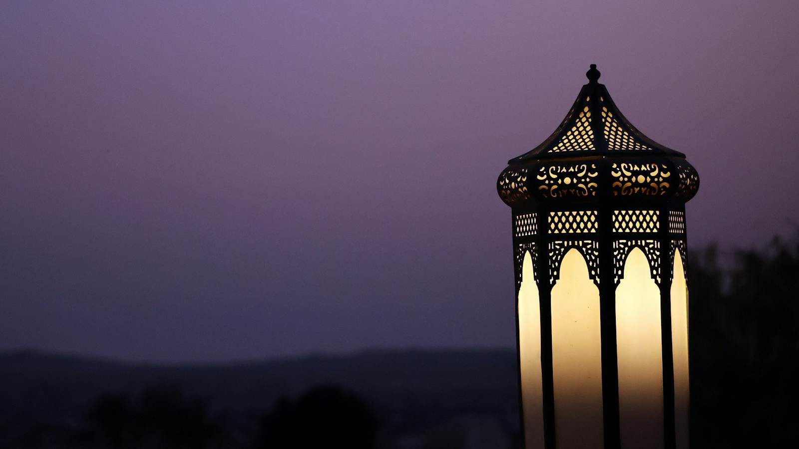 An ornate lantern lit against a purple twilight sky, representing the Ramadan and Eid retail season