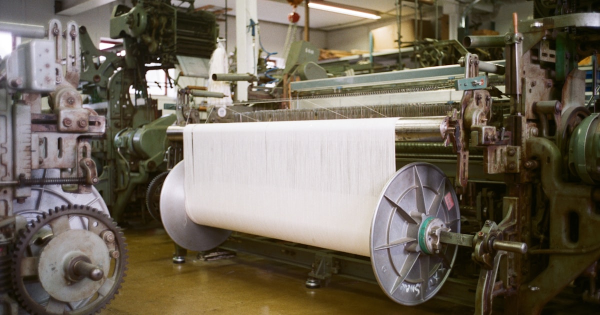Industrial textile looms with spools of thread, representing sourcing garment and textile materials from China