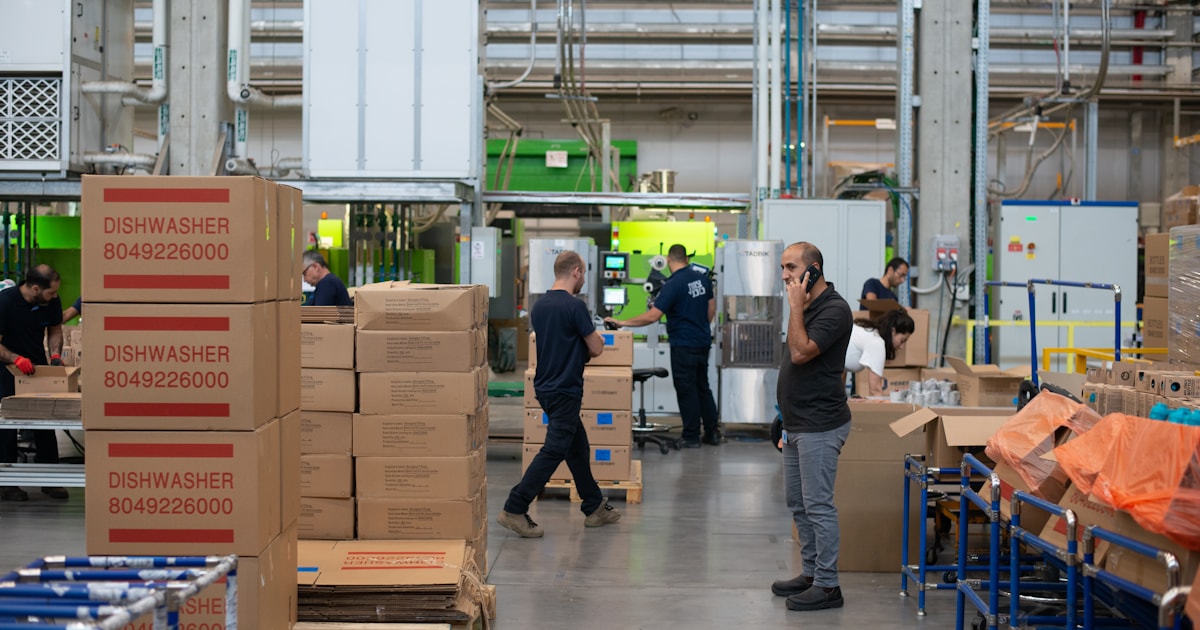 Warehouse worker inspecting cardboard boxes, representing why pre-shipment quality inspection saves money