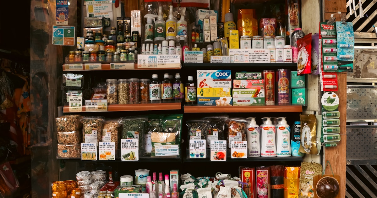 Small shop shelves densely stacked with a wide variety of goods, representing the small-commodities variety found in wholesale markets like Yiwu